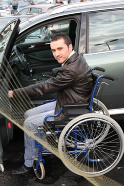Disabled Man enters car from wheelchair