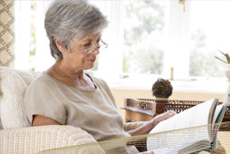 Mature woman reads a book in her living room